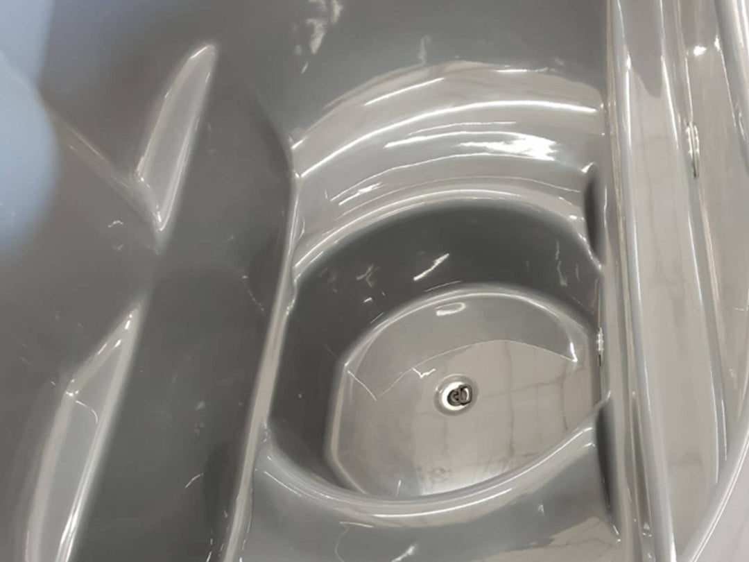 Close-up of grey Ofuro Cold Tub interior showing built-in ergonomic seat and center drain on a white background.