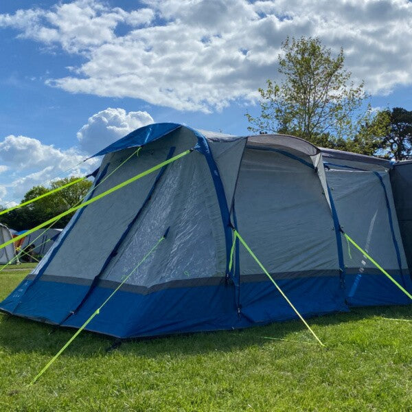 Olpro Loopo Breeze Infltable Campervan Awning in blue in a field with closed windows