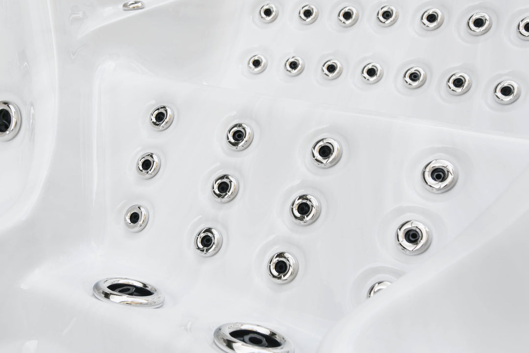 Close-up of stainless steel massage jets inside the Luso Spas The Party Pool Hot Tub, on a white acrylic surface.