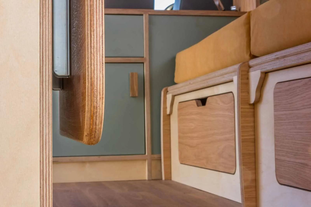 A close-up of the Campervan Rig Sideboard highlights the layered plywood edges, smooth cabinet doors, and integrated storage compartments beneath the seating area.