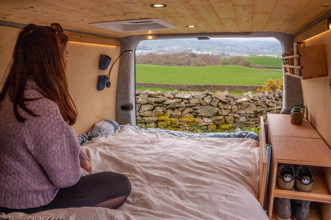 The Campervan Rig Sideboard is displayed with the bed platform fully assembled, creating a spacious sleeping area while maintaining accessible side storage and shelving.