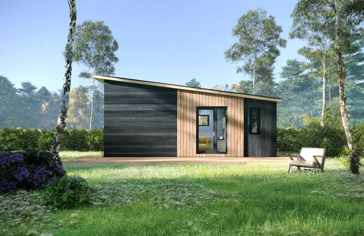 Front-facing view of a contemporary glamping pod with vertical timber slats and black cladding, surrounded by trees and greenery.