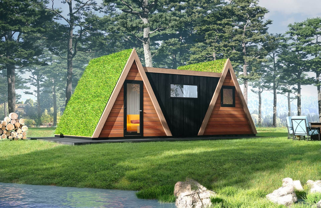 Lakeside A-frame duo glamping unit with green living roofs and black timber center, set among pine trees with firewood stack and outdoor dining.