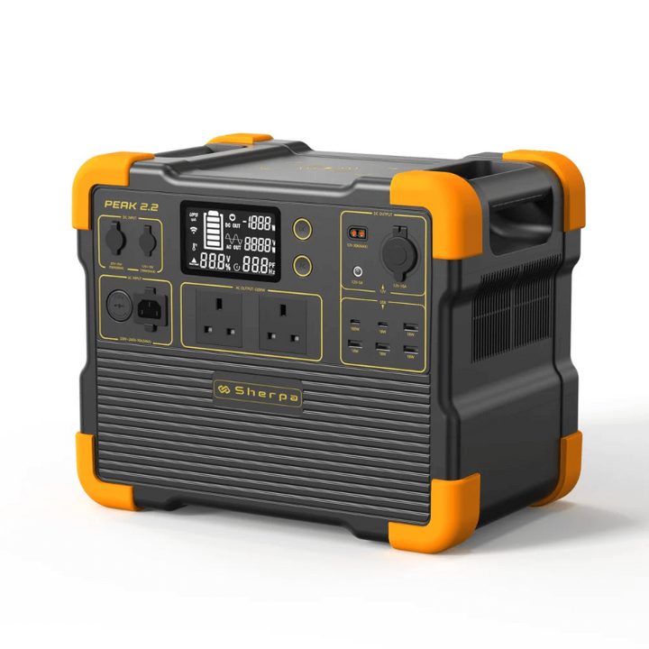 Angled front-left view of the Sherpa Peak 2.2 portable power station showing display, power ports, and bright orange protective corners, on a white background.
