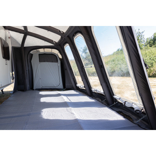 Interior view of Sunncamp Esteemed Air showing spacious floor area with textured matting and internal bedroom compartment