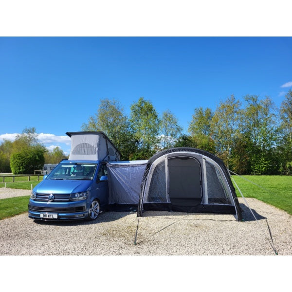 Sunncamp Swift Motor Air installed at a gravel campsite showing the full setup with pop-top roof visible