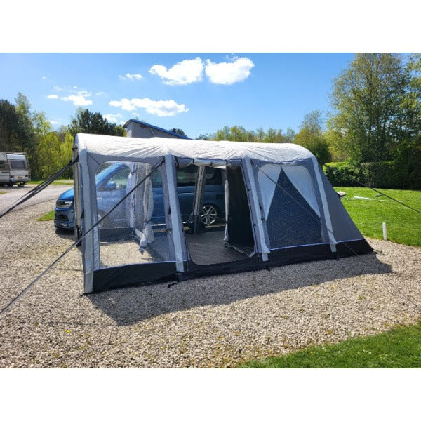 Full length view of Sunncamp Touring Motor Air Driveaway Awning connected to blue van showing complete setup and guy ropes