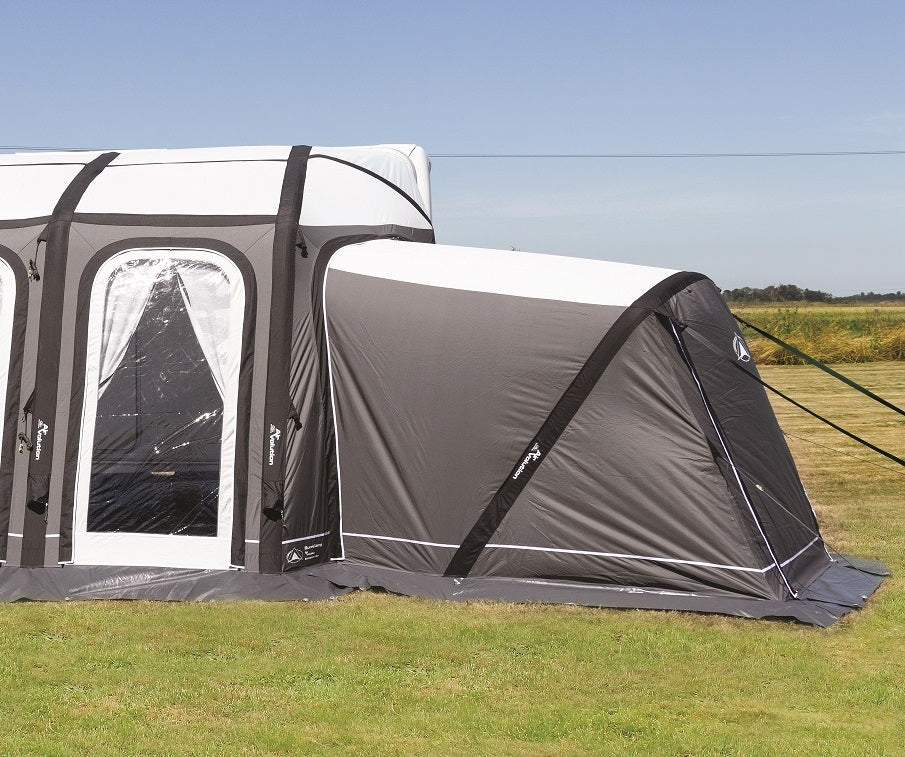 Sunncamp Icon Esteemed Air Annex in grey attached to an awning on a bright grass field outdoor.