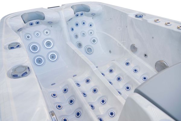 Close-up of Luso Spas The Platinum 1 Hot Tub interior in white marble finish highlighting massage jets and recliner seats.