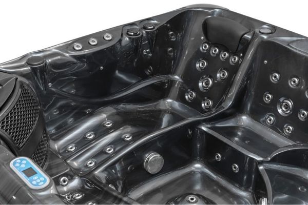 Interior view of dark acrylic Luso Spas The Platinum 9 Hot Tub with headrest and control panel on a white background.