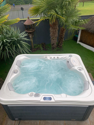 Overhead view of Luso Spas The Vepo Hot Tub in use with jets on and palm trees visible in the background.