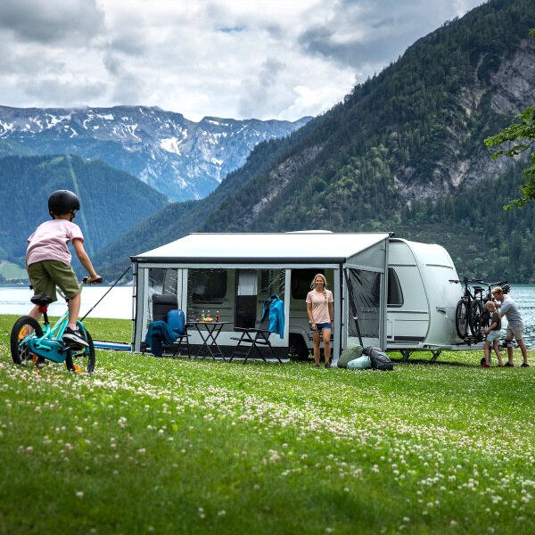 A Thule Residence G3 being used by a family in a field in front of mountains