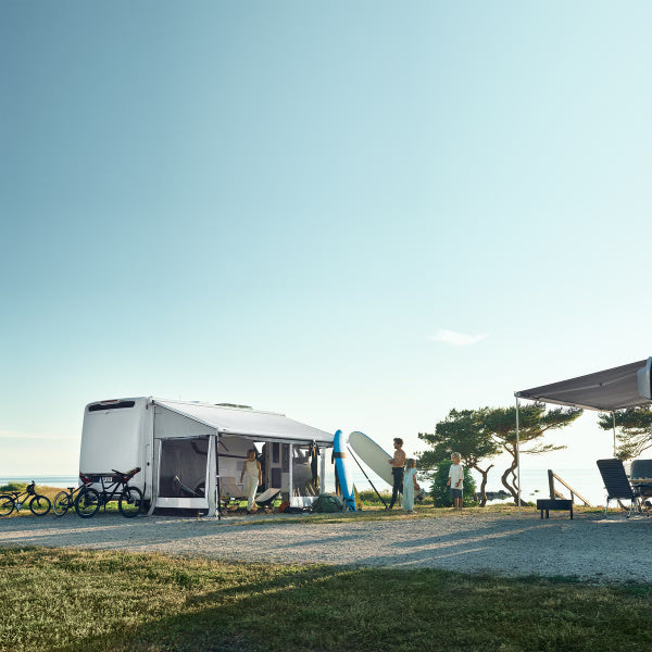 A family standing with surfboards in front of a Thule Residence Room