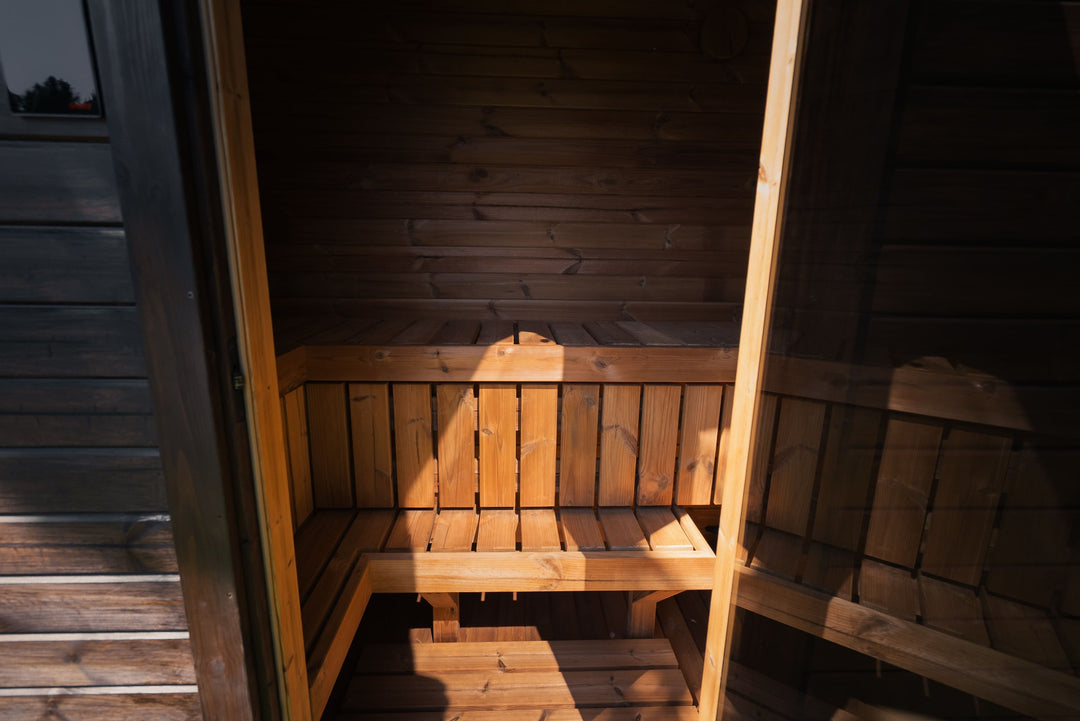 Ula Mini Outdoor Sauna with heater interior view featuring wooden bench and electric sauna heater.
