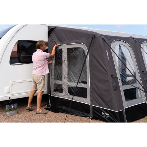 A man zipping in a panel on a Vango Balletto 260 Air Awning 