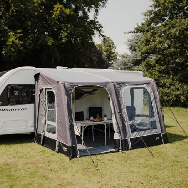 A Vango Balletto 330 Air Awning in dark fabric in a field