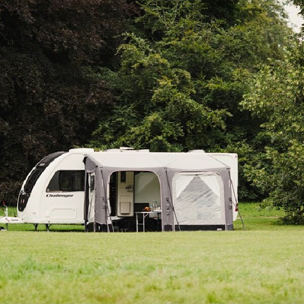 A Vango Balletto 390 Awning in a field with trees behind