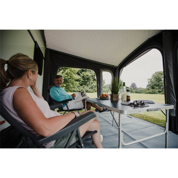 A couple sitting inside a Vango Riviera 390 Air Awning