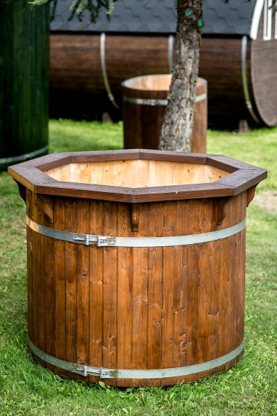 Viking Industrier 1.2m Cold Tub in dark-stained wood with a hexagonal top rim, secured with metal bands, situated on grass near a tree in a garden.