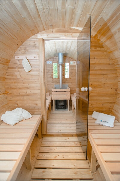 Interior of Viking Industrier Barrel Sauna with glass divider showing benches and stove.