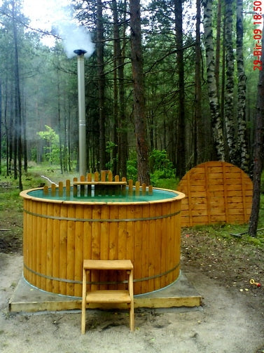Viking Industrier Polypropylene hot tub in forest clearing with smoke coming out of chimney, small steps in front and wooden screen nearby.