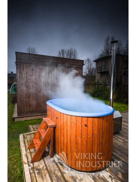 Viking Industrier Ofuro hot tub in use with steam rising from a blue fiberglass interior, placed on a wooden deck with a cloudy sky.