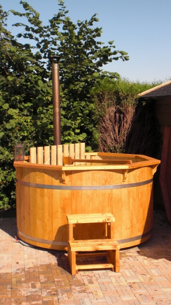 Viking Industrier Spruce hot tub with light wood and metal bands, placed on a brick patio with a two-step ladder, under a sunny sky