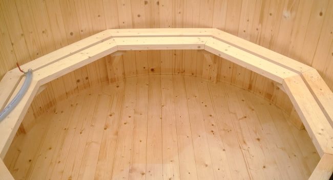 Interior view of a Viking Industrier Spruce hot tub with light wood seating and walls.