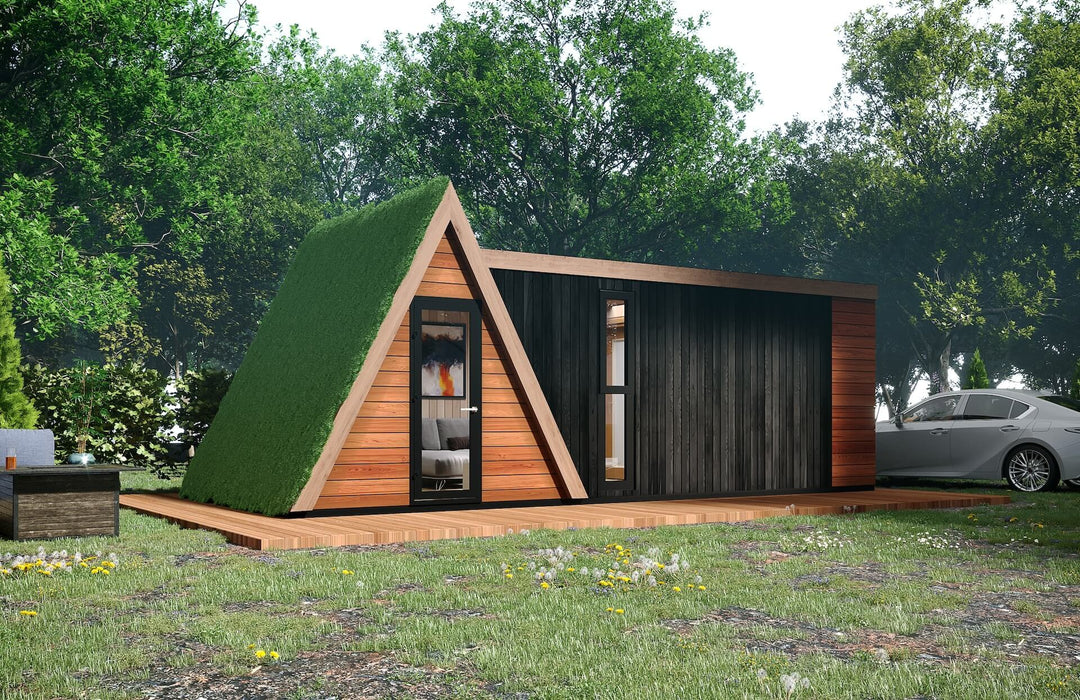 Outdoor view of the glamping unit with a green roof and wooden deck, surrounded by trees, flowers, and a parked car.
