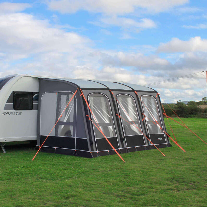 Camptech Starline Elite 390 caravan awning attached to a white Sprite caravan on a grassy campsite with cloudy sky background.