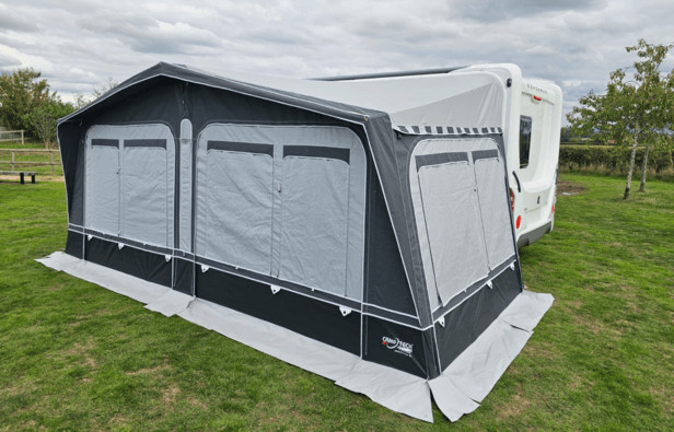 Camptech Westminster CS awning with matching side annex attached to a Coachman caravan on a campsite.