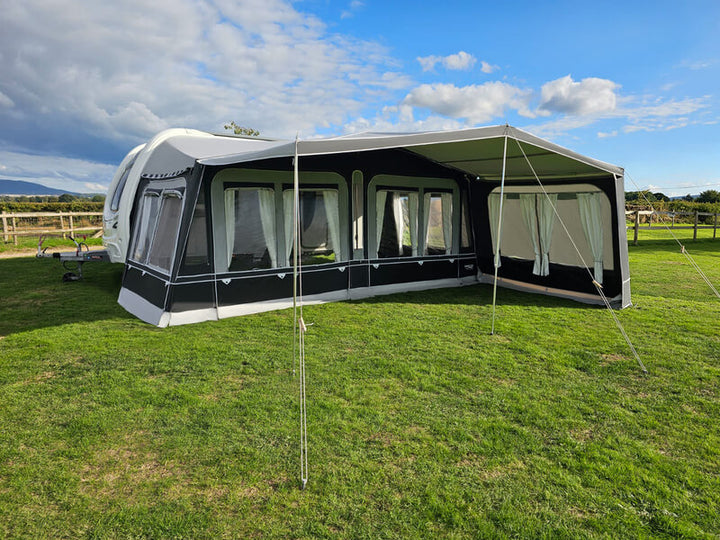 Camptech Westminster CS full caravan awning with clear windows and curtains on a grassy campsite.