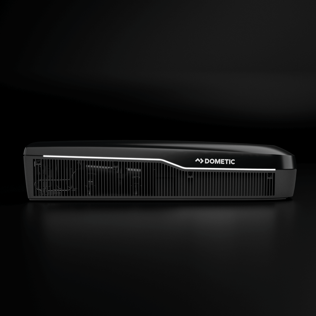 Side profile of the Dometic FreshJet FJX7 3000 in black. Features a lit LED strip and bold Dometic logo, with horizontal vents in a plain black background.