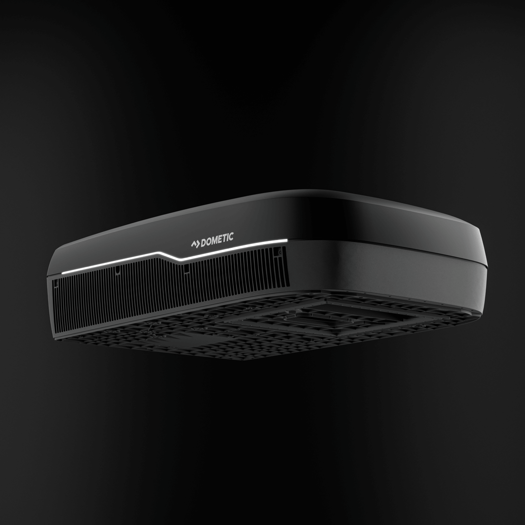 Low-angle underside view of the black Dometic FreshJet FJX7 3500. The design highlights the undercarriage ventilation structure and LED-lit front grille with black background.