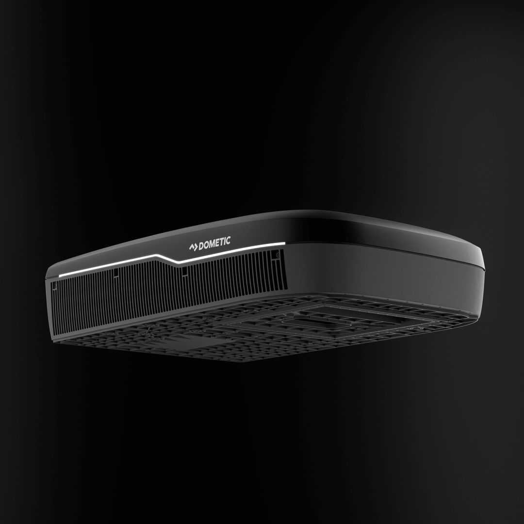Low-angle view of the Dometic FreshJet FJX7 3000 in black, showing the detailed undercarriage design and front grille, on plain black background.
