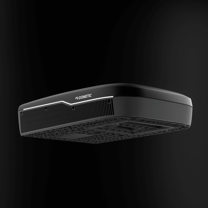 Low-angle view of the Dometic FreshJet FJX7 3000 in black, showing the detailed undercarriage design and front grille, on plain black background.