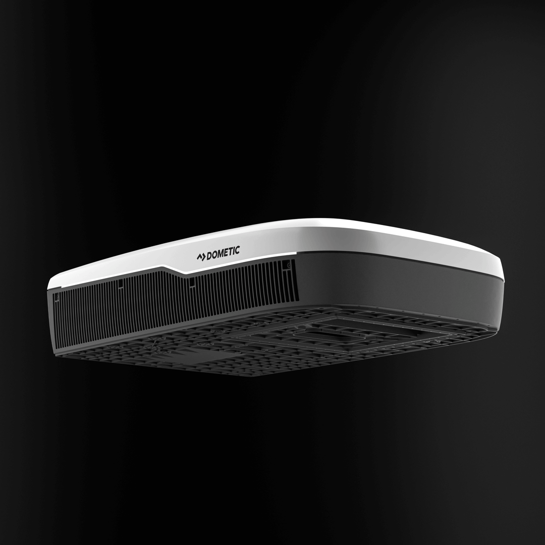 Low-angle view of the Dometic FreshJet FJX7 3000 in white, emphasizing the underside structure and large ventilation grille, with black background.
