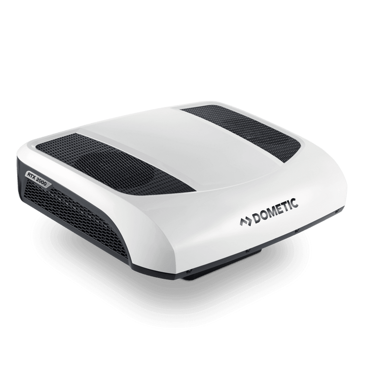 High-angle front-left view of the Dometic CoolAir RTX 2000 12V air conditioner. The unit has a sleek white top housing, two black mesh vent panels, and subtle curves for low drag. Visible RTX 2000 branding on side vent, on a transparent background.