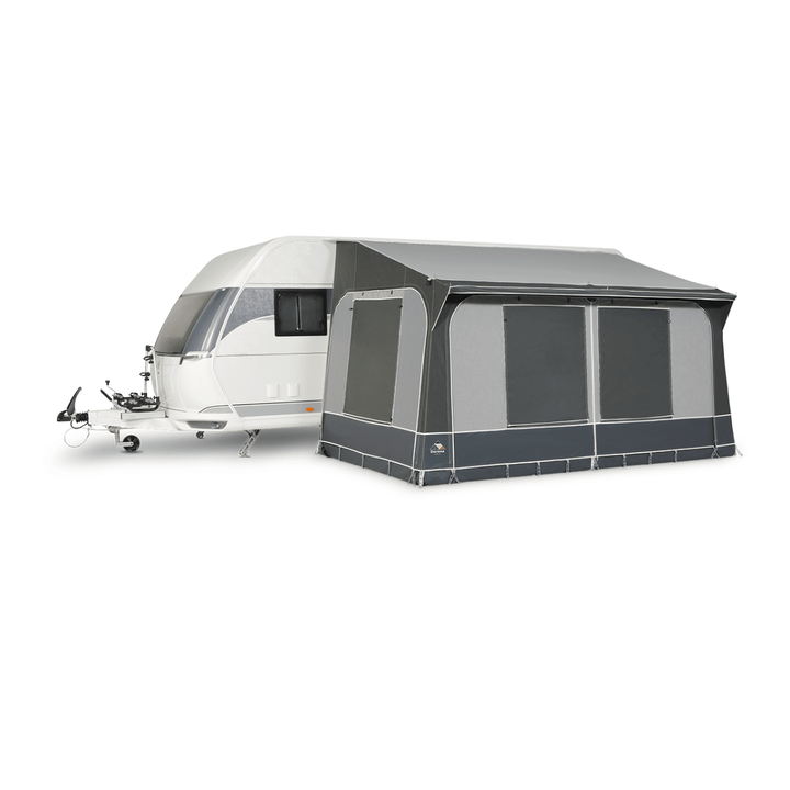 Dorema Quartz 330 Deluxe attached to a white touring caravan, featuring enclosed grey panels, large tinted windows, and a full-length canopy on a white background.