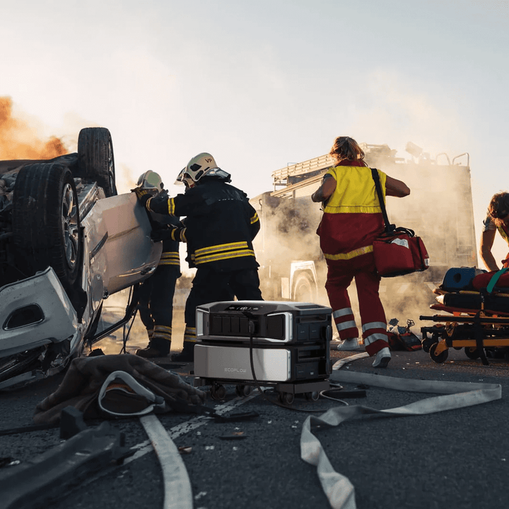 EcoFlow Delta Pro Ultra powering an emergency rescue scene with firefighters and medics beside an overturned car on a smoky roadway.