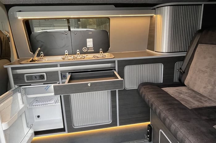 Ford Transit Custom Campervan Kitchen Unit LWB kitchen configuration with sink, hob, storage cupboards, and bench seat inside van interior.