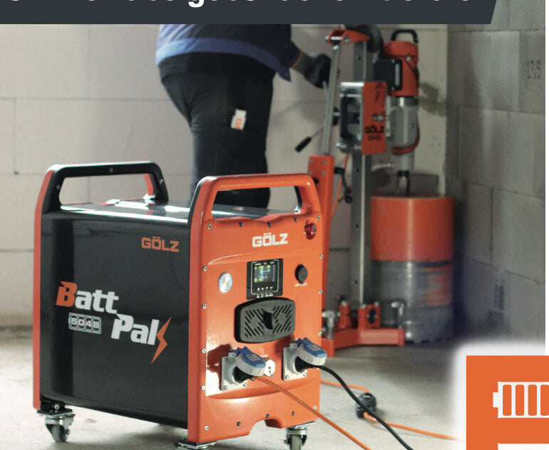 The GÖLZ BattPak 5048 battery generator powers a core drilling machine inside a construction site, with a worker drilling into a concrete wall.