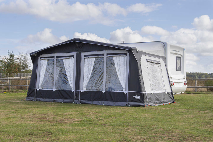 Camptech Hampton DL air awning attached to a Coachman Pastiche caravan on a grassy field with fencing and trees in the background