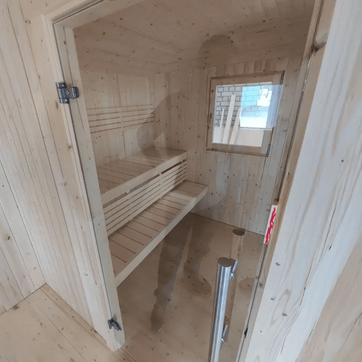 Interior view of the InMedias Wagon Log Sauna with wooden benches.