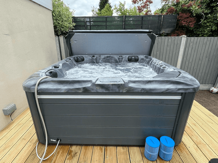 Side view of Luso Spas The Aquarius Plug & Play Hot Tub in operation on a wooden deck with bubbling water on an outdoor background.