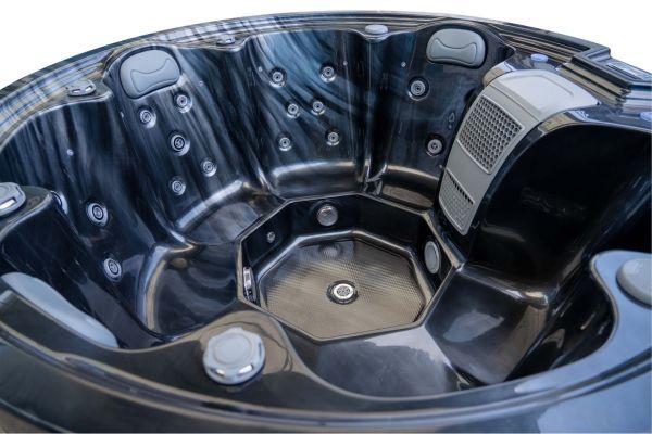 Angled interior view of Luso Spas The Orb Hot Tub in dark marble finish showing ergonomic seating layout and multiple massage jets.