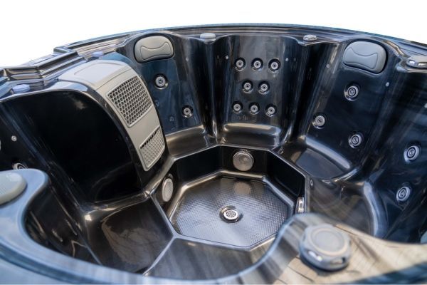 Interior close-up of Luso Spas The Orb Hot Tub in black marble finish featuring hydrotherapy jets, headrests, and textured seating.