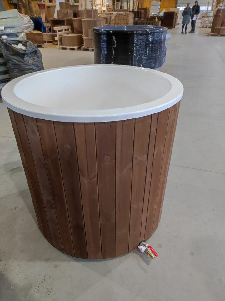 Brown wooden cold tub with white interior placed on a warehouse floor, with another tub and industrial shelving in the background.