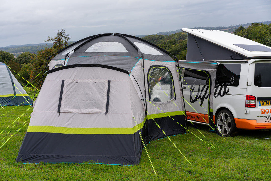 Rear view of the OLPRO Hive Campervan Awning attached to a campervan on a grassy campsite.