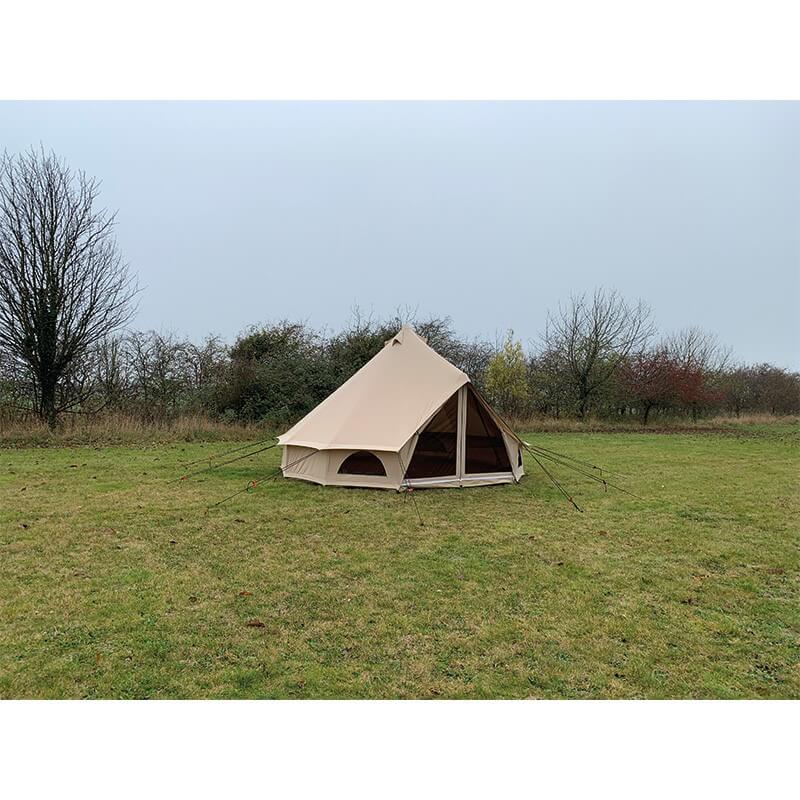 Rear side view of the Quest Leisure Signature 5M Classic bell tent set up on green grass with sky.